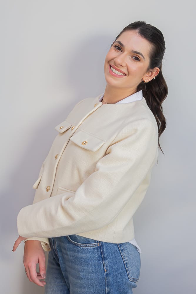 Dra. Carla Eid Gobbi sorrindo, de casaco claro